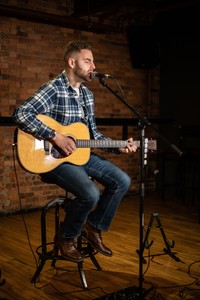 Rob Forman singing and playing the acoustic guitar